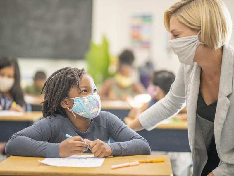 6 year old, African American student wearing a protective face mask in class
