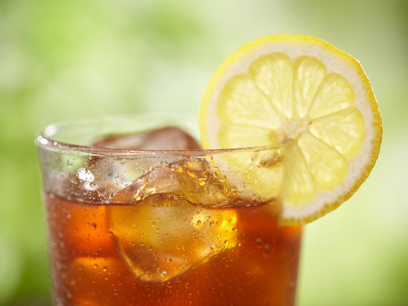 A close-up of a glass of iced tea with lemon