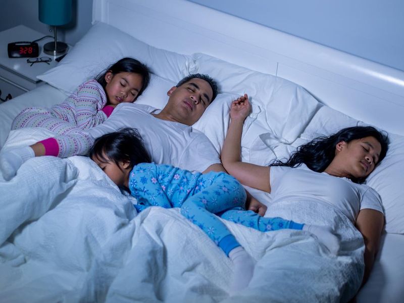 A family asleep on the same bed