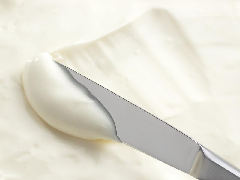 A knife swiping into some cream cheese