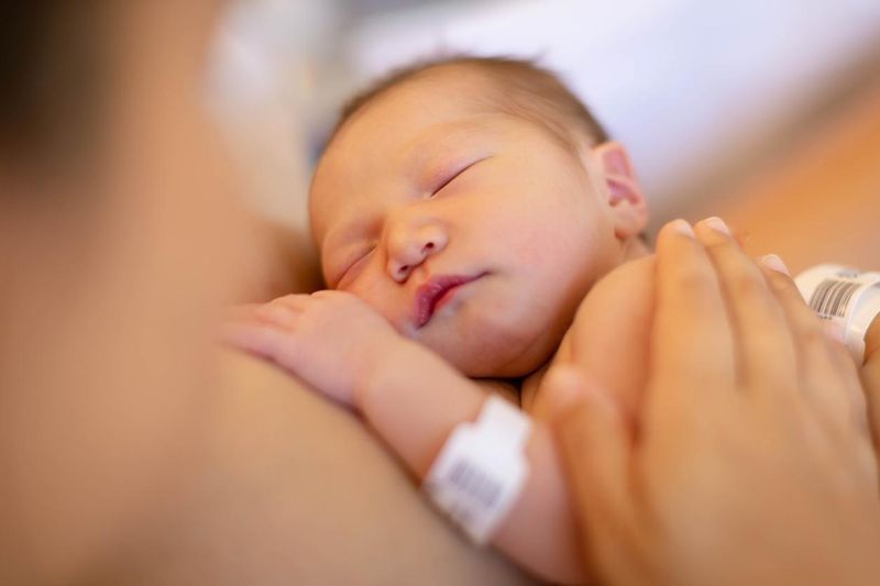 A mom holding newborn baby on chest, having skin on skin time