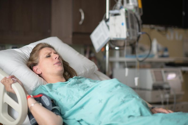 A Pregnant Woman Tries Breathing Through Labor Pains stock photo