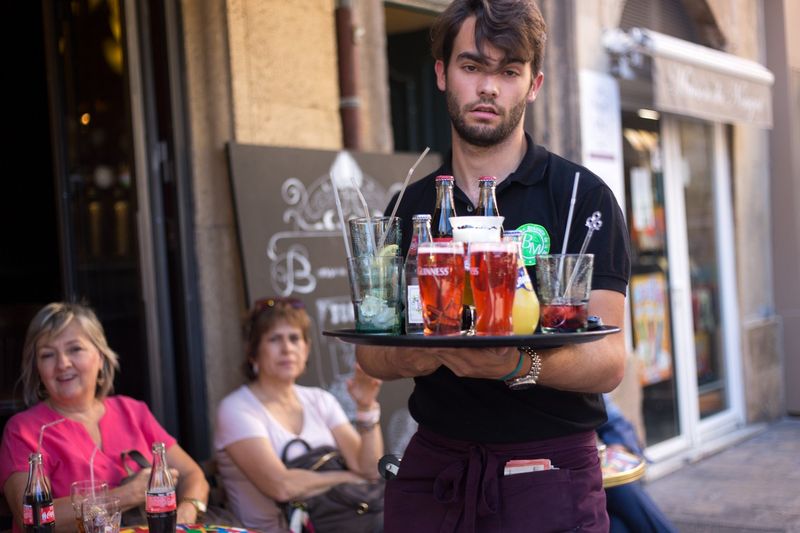 A waiter serving beer in France