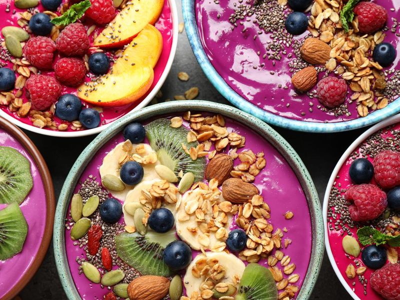 Acai smoothie with toppings in bowls on table