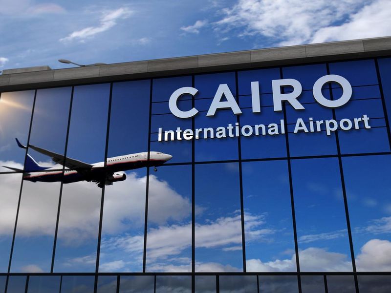 Airplane landing at Cairo mirrored in terminal
