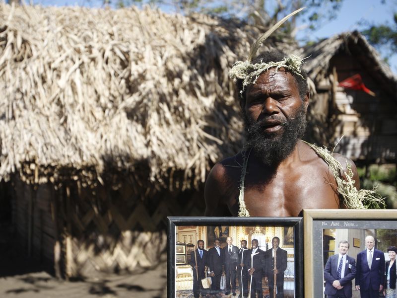 Albi Nagia poses with photographs of Prince Philip in Yakel, Tanna island, Vanuatu