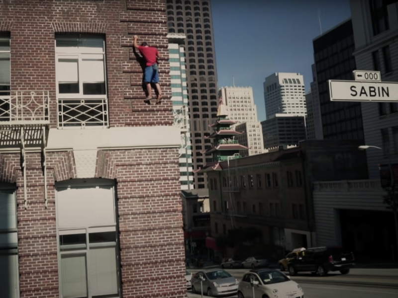 Alex Honnold climbing a brick building in San Francisco