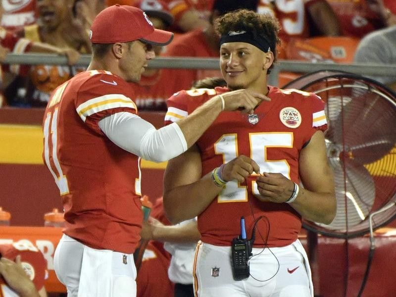 Alex Smith talks to Patrick Mahomes during a 2017 game