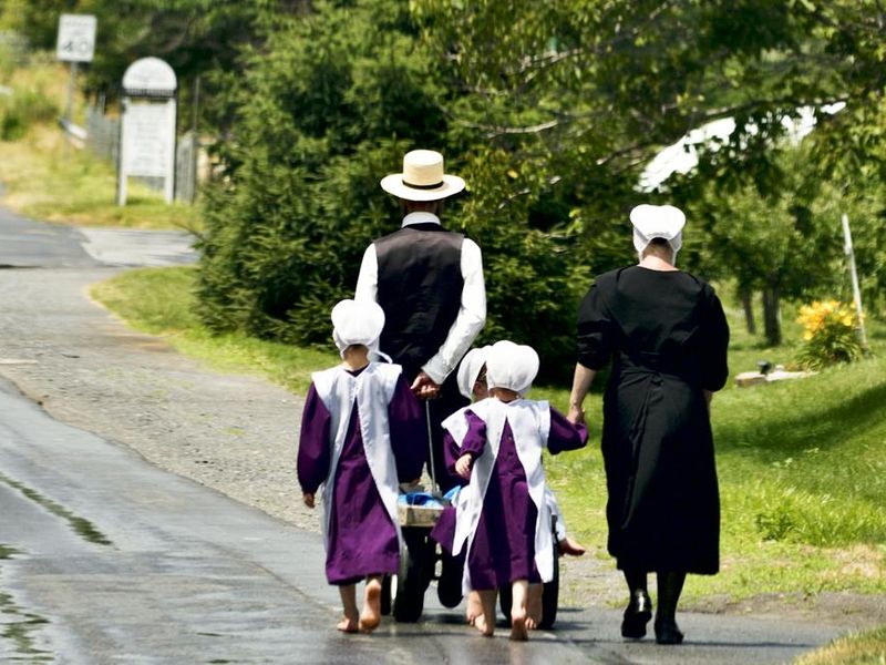 Amish family walks bare feet over a country road in the heart of rural Lancaster County