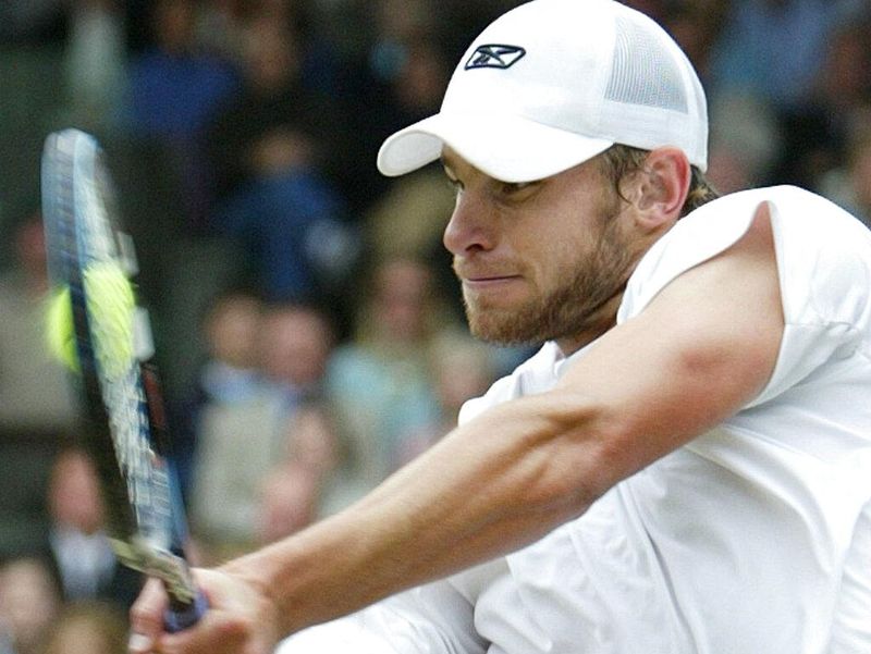 Andy Roddick plays a return to defending champion Roger Federer