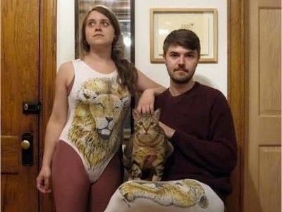 Awkward photo of a couple and their cat
