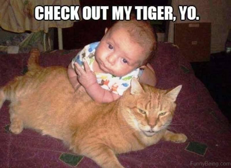 Baby making a funny face next to pet cat