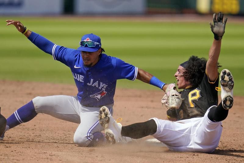 Blue Jays second baseman Santiago Espinal and Pittsburgh Pirates shortstop Cole Tucker slides into second