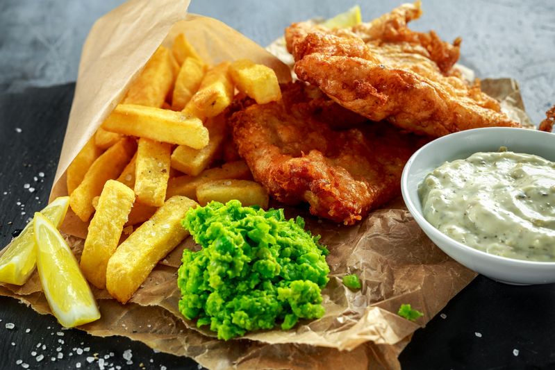 British traditional fish and chips with mashed peas, tartar sauce and lemon