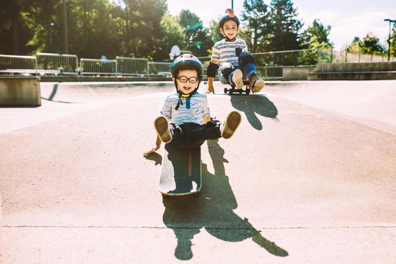 Brothers riding skateboards