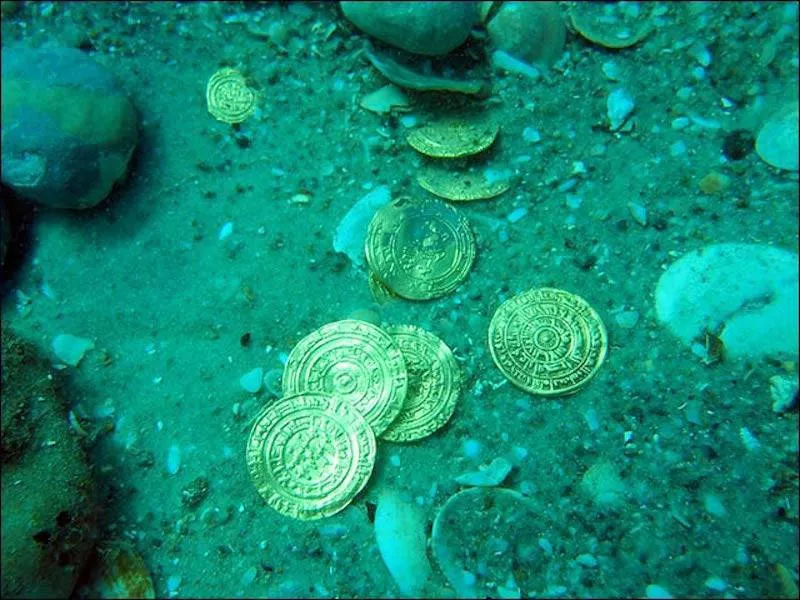 photographie de pièces d'or sous l'eau