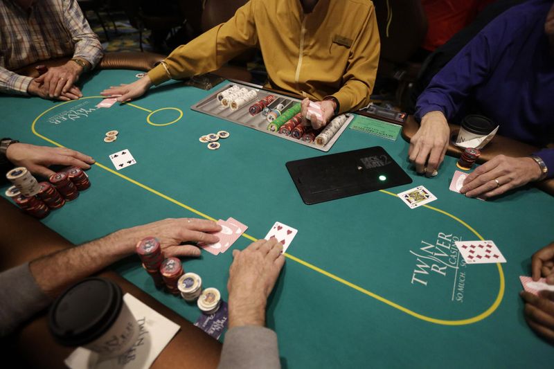 Card dealer deals a game of poker to patrons at Twin River Casino in Lincoln, Rhode Island