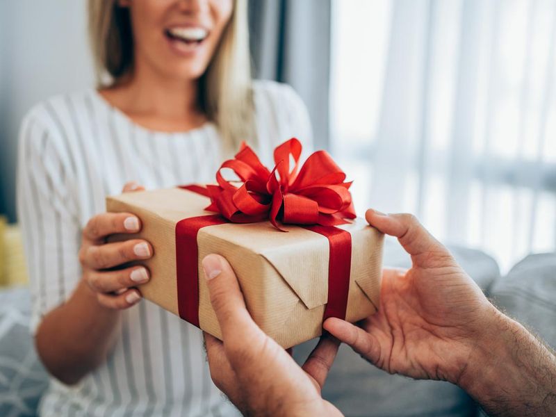 Cheerful young woman receiving a gift from her boyfriend