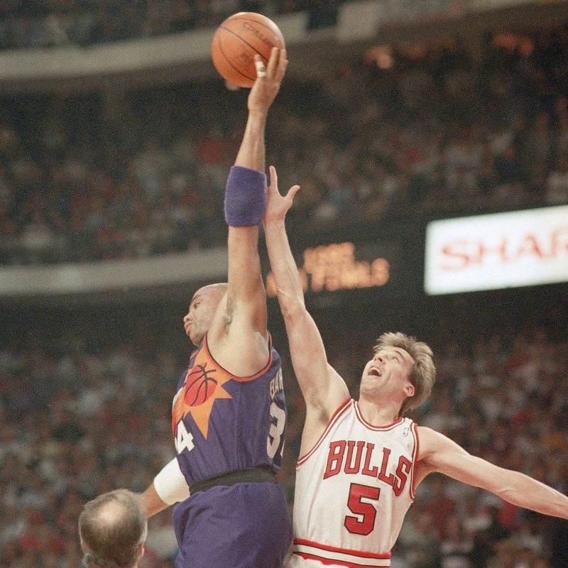 Chicago Bulls John Paxson reaches high to battle Phoenix Suns Charles Barkley for rebound