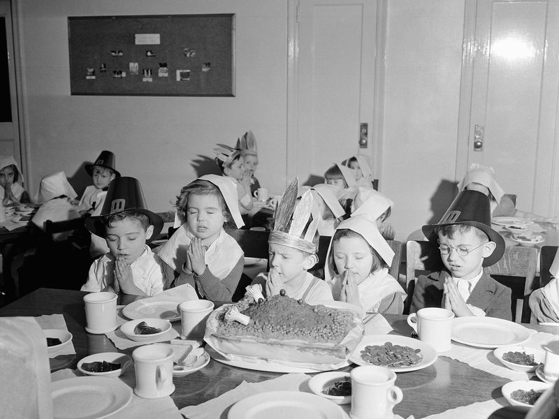 Children saying grace before Thanksgiving dinner in 1940