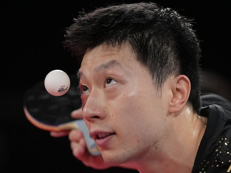 China's Ma Long eyes ball as he serves in 2020 Summer Olympic Games
