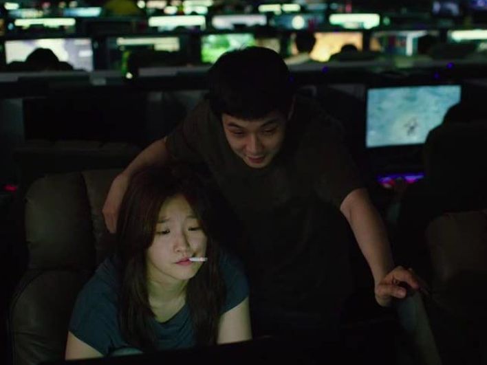Choi Woo-sik and Park So-dam looking at screen in Parasite