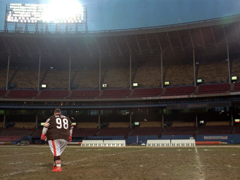 Cleveland Browns superfan "Big Dawg," aka John Thompson, walks across deserted field at Cleveland Stadium in 1995