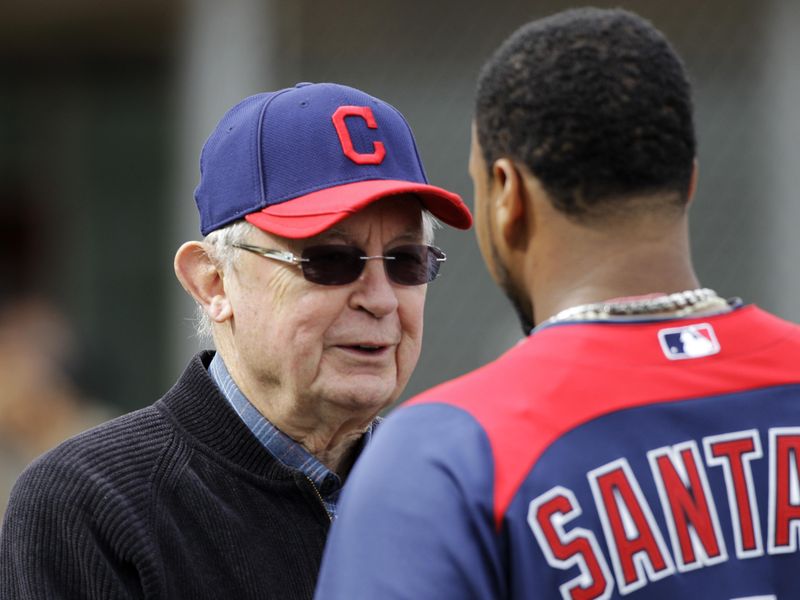 Cleveland Indians owner Larry Dolan talks with catcher Carlos Santana