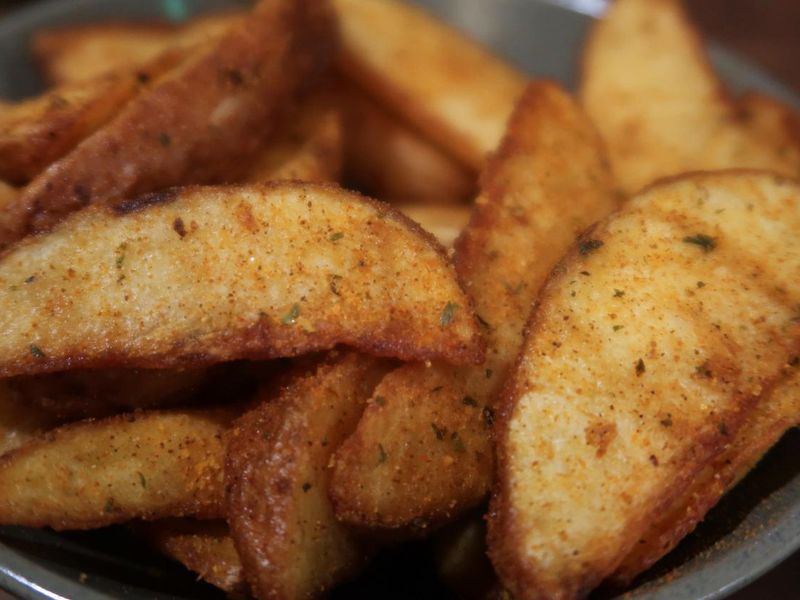 Close-up image of freshly cooked, homemade, seasoned potato wedges