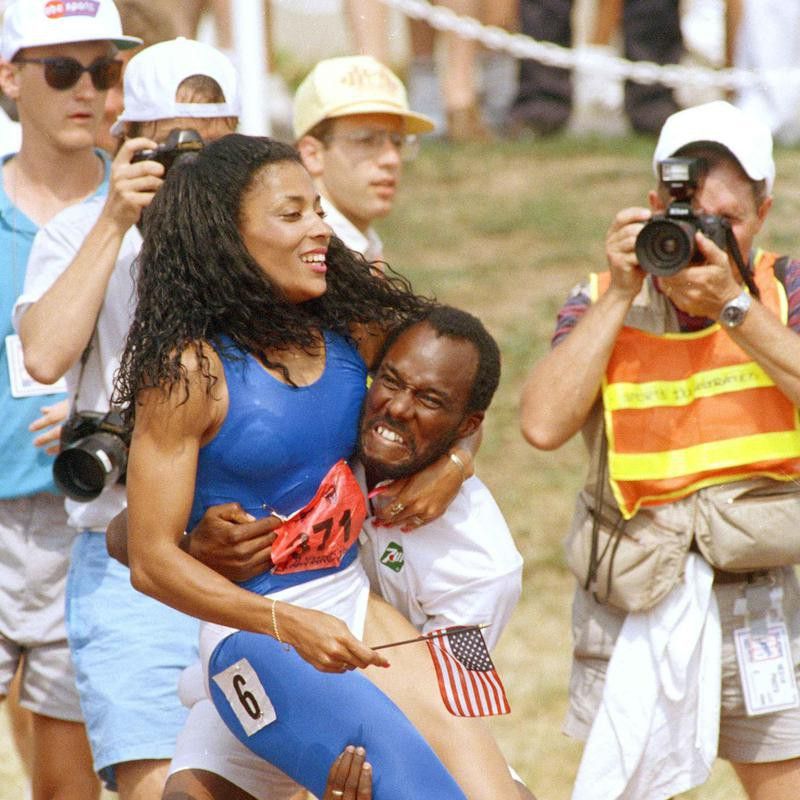Coach Bob Kersee grabs world record holder Florence Griffith-Joyner after she won