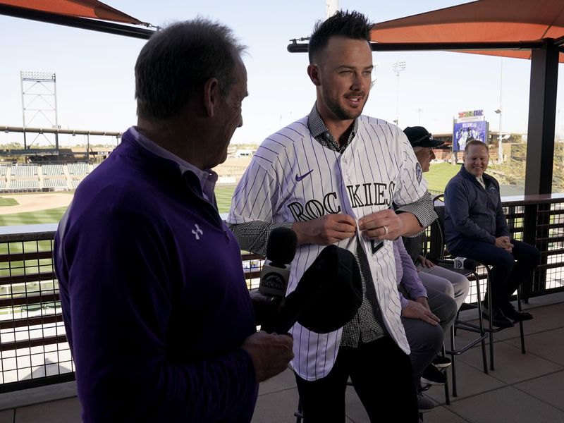 Colorado Rockies baseball team owner Charles Monfort helps Kris Bryant
