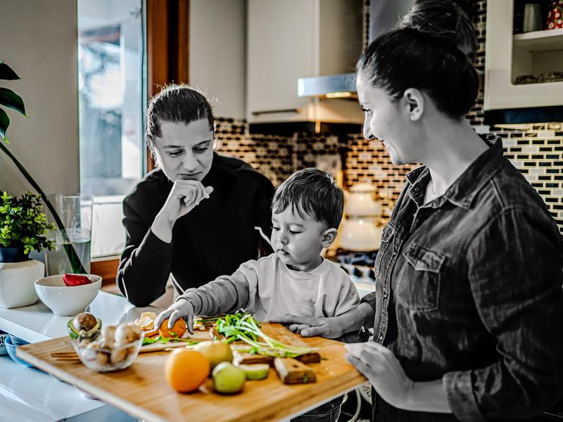 Couple and their child preparing dinner in kitchen