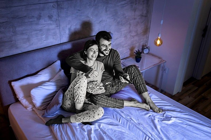 couple watching movie in bed