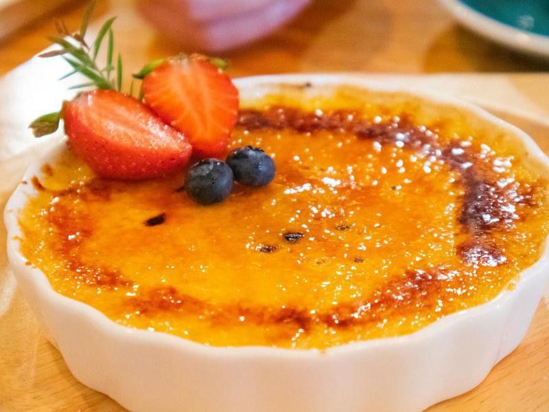 Creme brulee topped with strawberries and blueberries