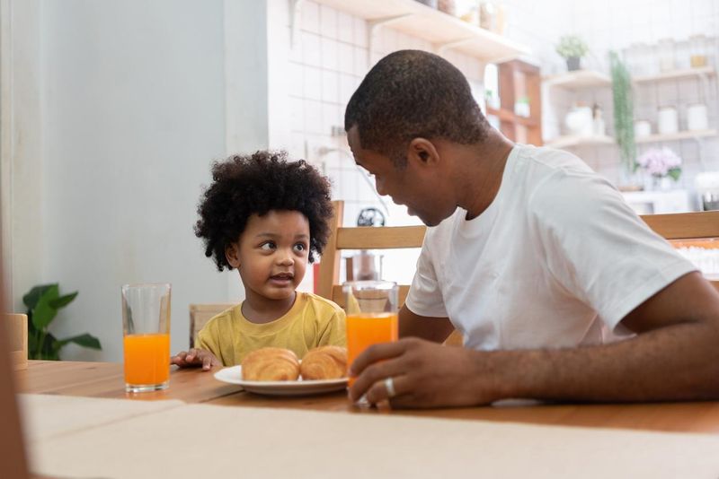 Dad practicing active parenting by sharing breakfast with his child