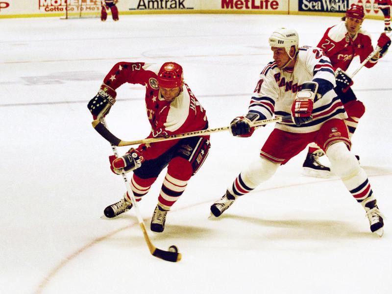 Dale Hunter and Jeff Beukeboom fight for the puck