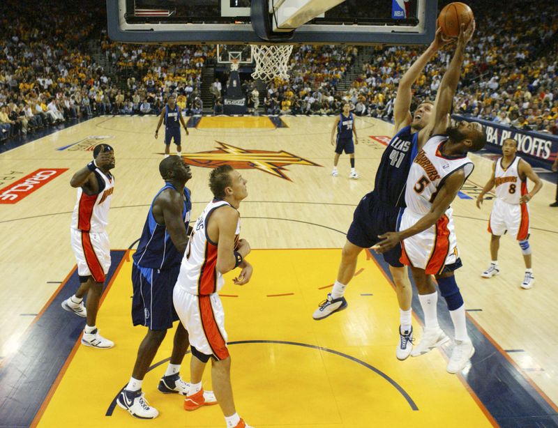 Dallas Mavericks' Dirk Nowitzki fights for rebound against Golden State Warriors' Baron Davis