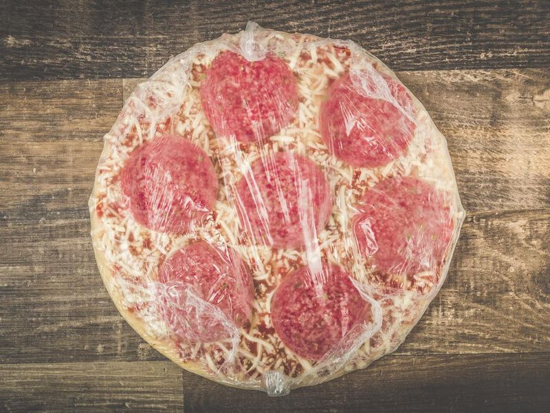 Delicious mouth watering raw frozen pizza on a kitchen table