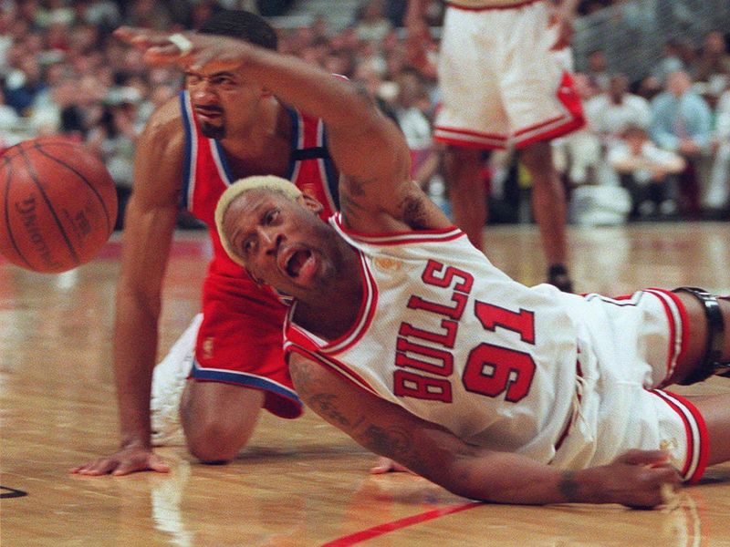 Dennis Rodman dives for ball on the court