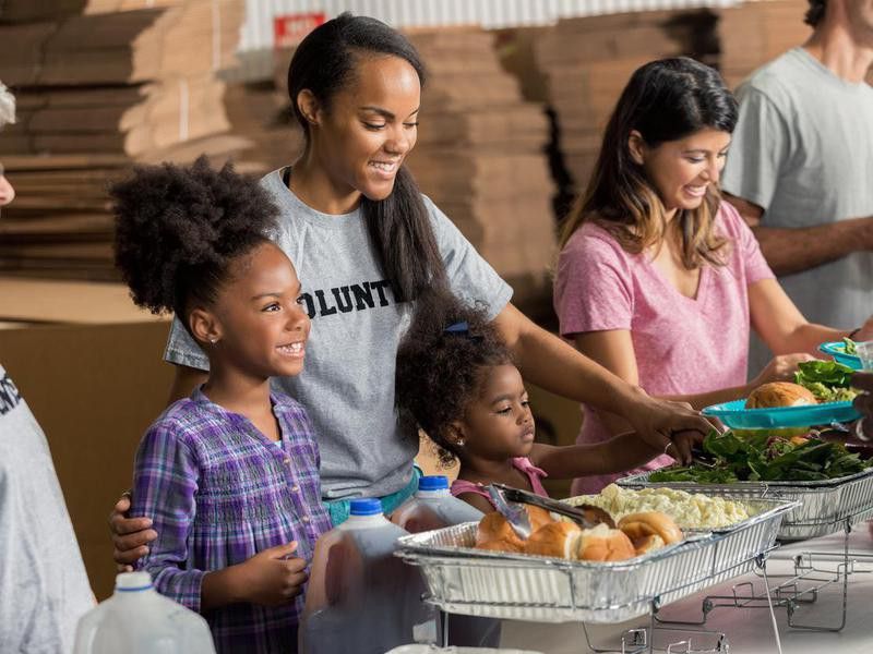 Diverse family volunteers together in soup kitchen