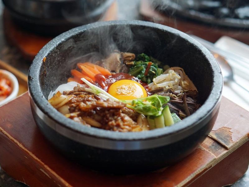 Dolsot bibimbap - Korean mixed rice, Include steamed rice, vegetables, pork and fried egg on top, served in a hot stone pot.