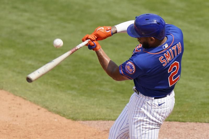 Dom Smith bats during spring training game