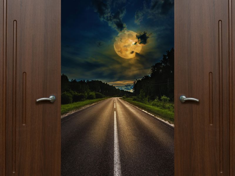 Door opening to an open road under a big moon