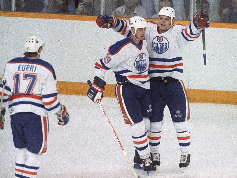 Edmonton Oilers Esa Tikkanen congratulated by teammate Wayne Gretzky after scoring