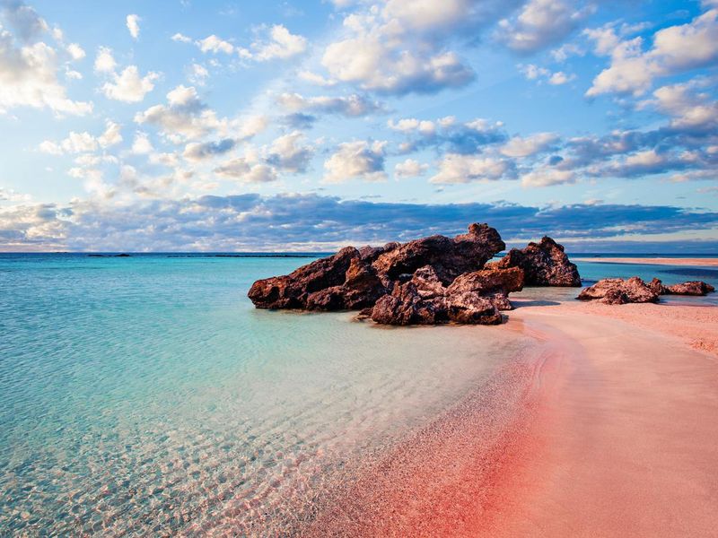 Elafonissi beach with pink sand against blue sky with clouds on Crete, Greece