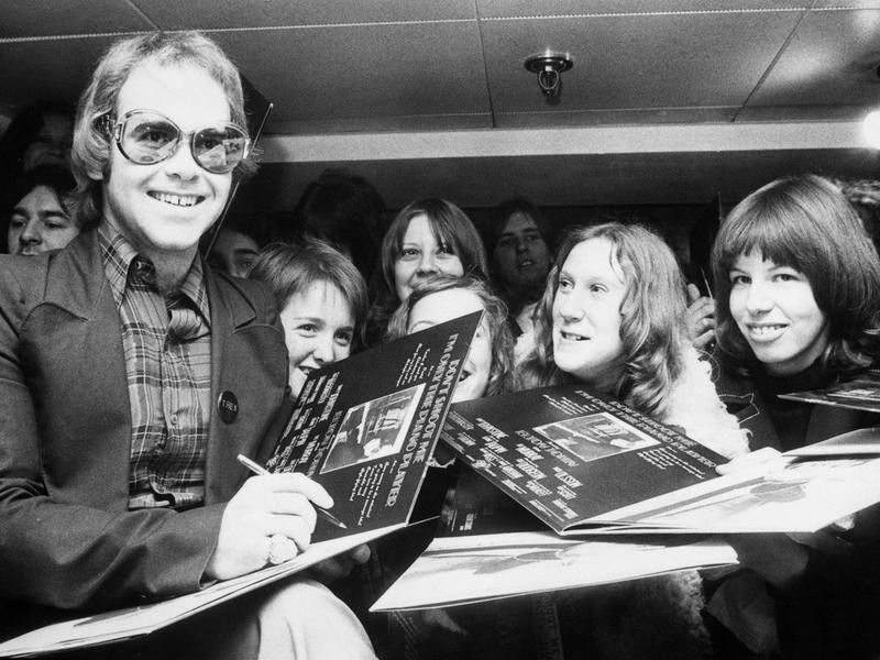 Elton John signs autograph