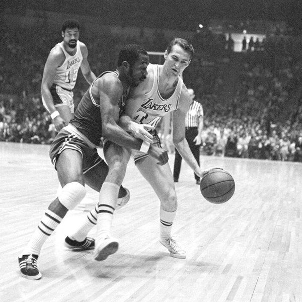 The Lakers' Jerry West tries to take the ball down the court but finds himself closely pressed by Boston's Emmette Bryant in the first period of the opening game of he NBA championship playoff in Los Angeles, April 23, 1969. That's the Lakers' Wilt Chamberlain in background. (AP Photo/Harold P. Matosian)
