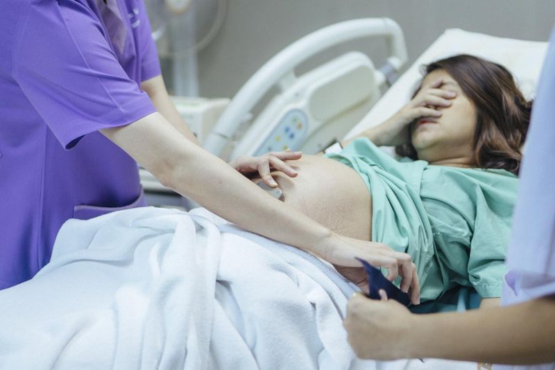 Examining the belly of a pregnant woman