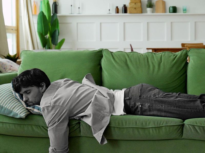Exhausted young man napping on sofa