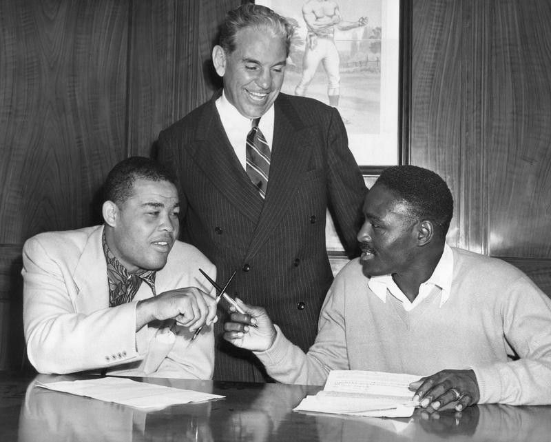 Ezzard Charles and Joe Louis signing contracts